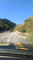 Carreta com carga de madeira tomba e deixa pessoa ferida na Via Dutra, em Piraí